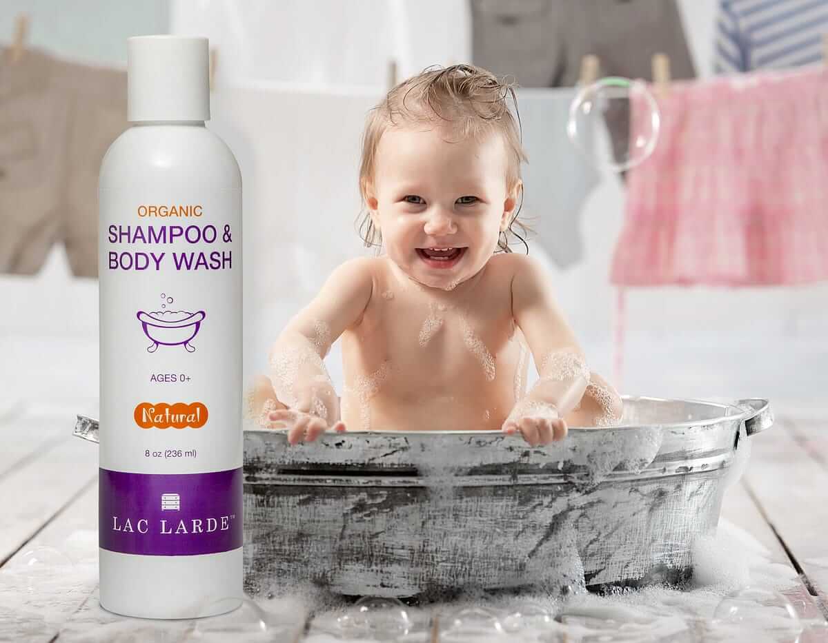 Happy baby enjoying a bath with organic shampoo and body wash, promoting baby health and grooming.