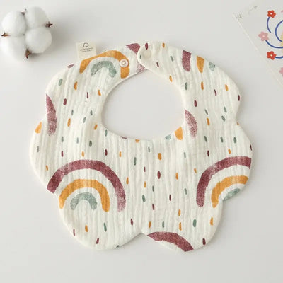 Colorful flower-shaped cotton baby bib with rainbow and dot patterns, perfect for feeding and drooling.