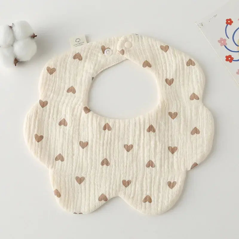 Fashionable flower-shaped baby bib with heart patterns, perfect for feeding and drooling, made from soft cotton.