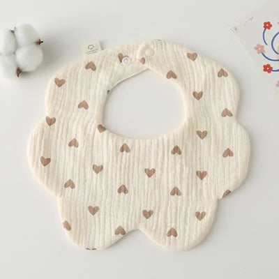 Fashionable flower-shaped baby bib with heart patterns, perfect for feeding and drooling, made from soft cotton.