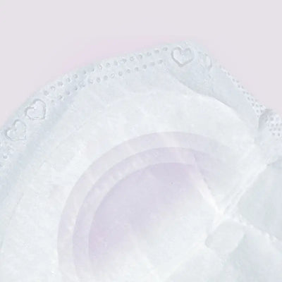 Close-up of a soft, disposable nursing breast pad featuring heart pattern on the edge, designed for comfort and absorbency.
