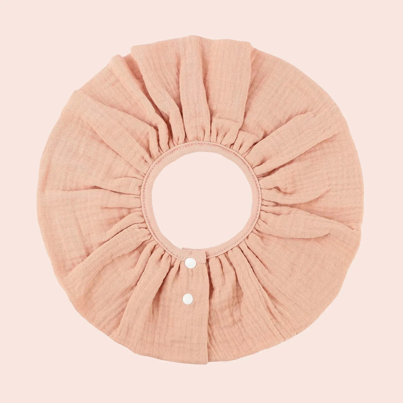 Insular baby bib in soft peach cotton, absorbent and breathable, perfect for infants 0-1 year, floral design.