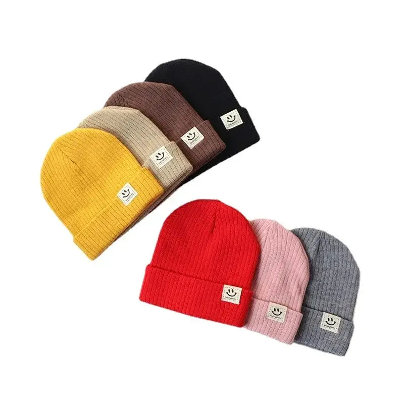 Set of colorful knitted baby hats with smiley face patches for boys and girls, perfect for winter wear.
