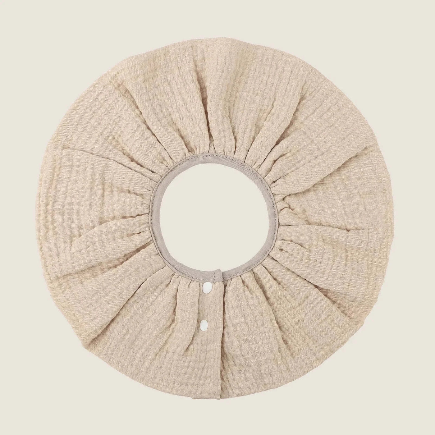 Absorbent infant burp cloth in soft beige cotton, designed for newborns, featuring a breathable four-layer gauze structure.