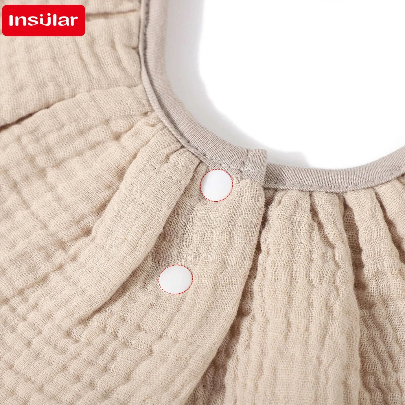 Insular absorbent baby bib detail, showcasing soft cotton fabric and snap buttons for easy fastening.