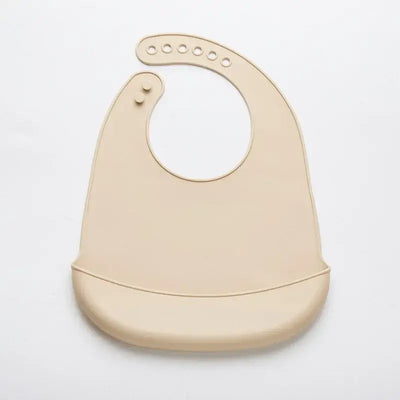 Adjustable waterproof silicone baby bib in beige color, soft and easy to clean, designed for drooling infants.