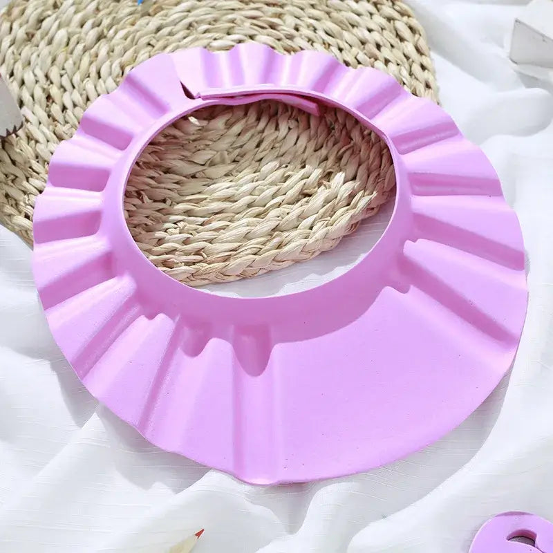 Baby shower soft cap in pink, adjustable hair wash hat for kids to protect ears during bathing.