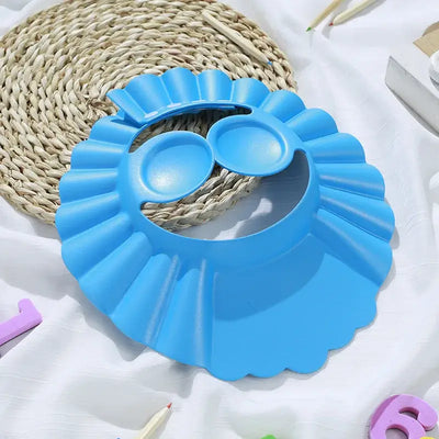 Blue adjustable baby shower cap with ear protection, designed for safe shampooing and bathing.