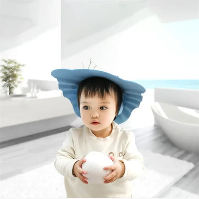Toddler wearing a blue adjustable hair wash cap for safe bathing and shampooing.