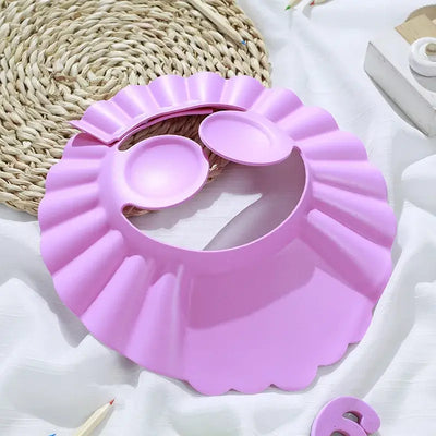 Pink adjustable baby shower cap designed for safe shampooing, featuring ear protection and a flexible, lightweight design.