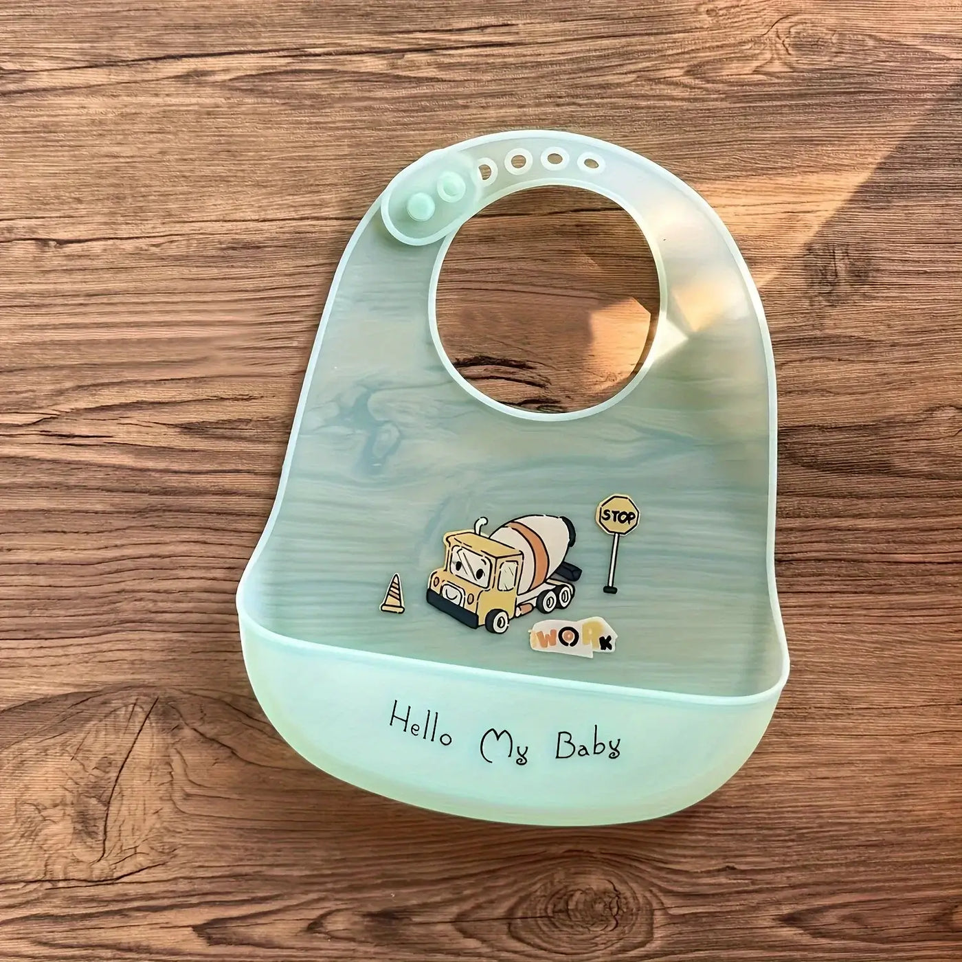 Cute waterproof baby bib featuring cartoon construction truck design, ideal for feeding toddlers and kids.